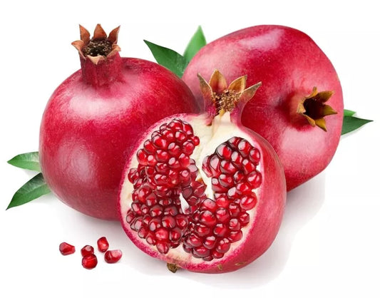 Pomegranate with a cut open to reveal seeds on a white background